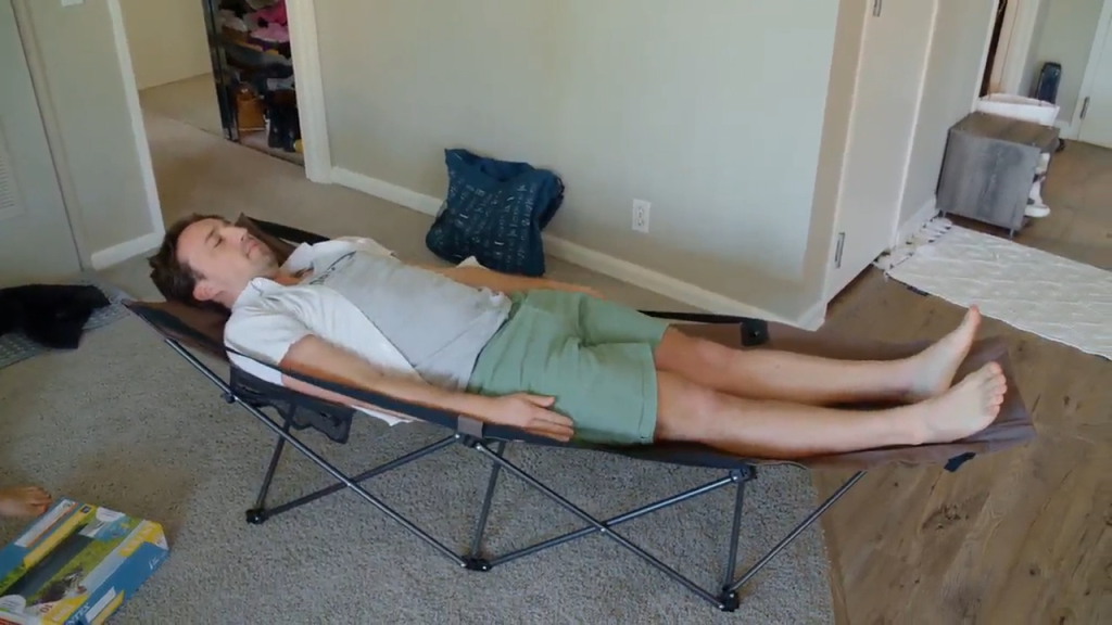 Man sleeping on a portable cot.