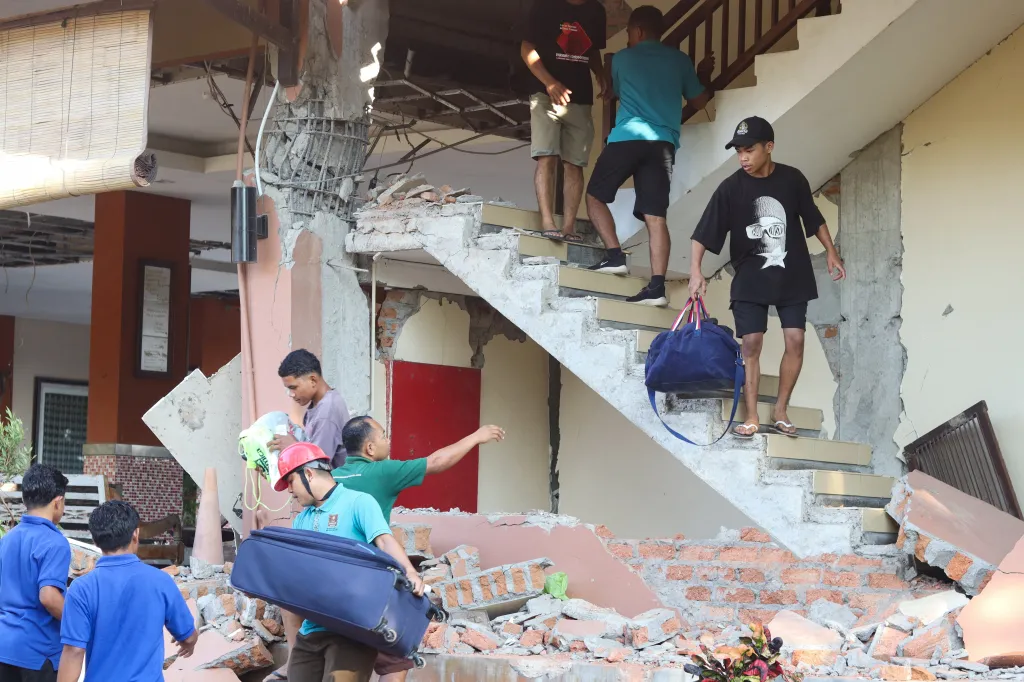 People evacuate from a destroyed hotel in Labuan Bajo, Indonesia.