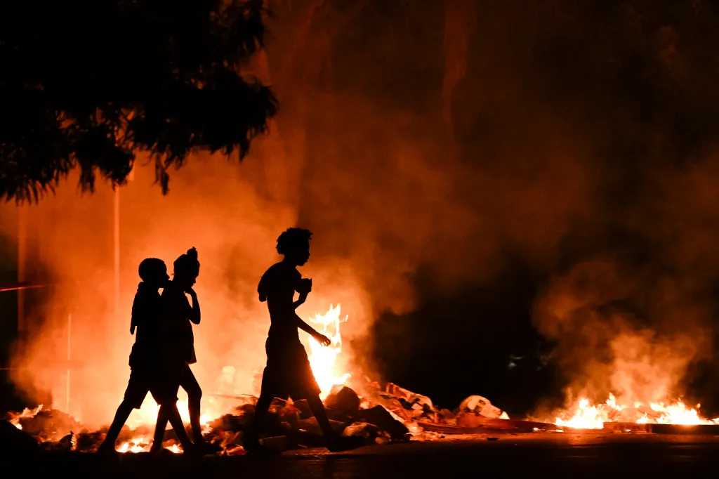 People walk past a fire set by demonstrators during a protest against the lack of energy and blackouts in the Lawton neighborhood in Havana on May 14, 2026.