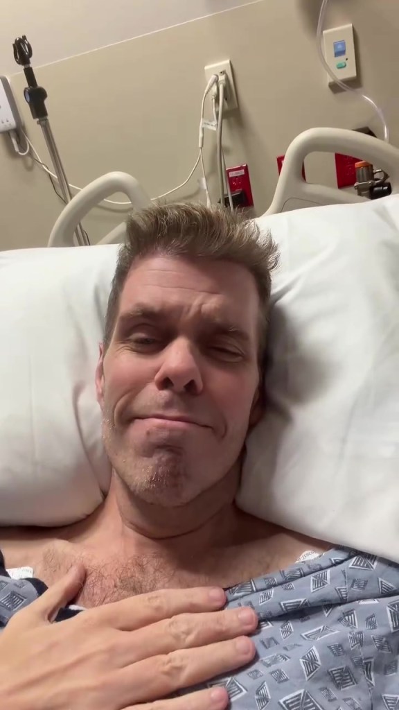 Perez Hilton lying in a hospital bed.
