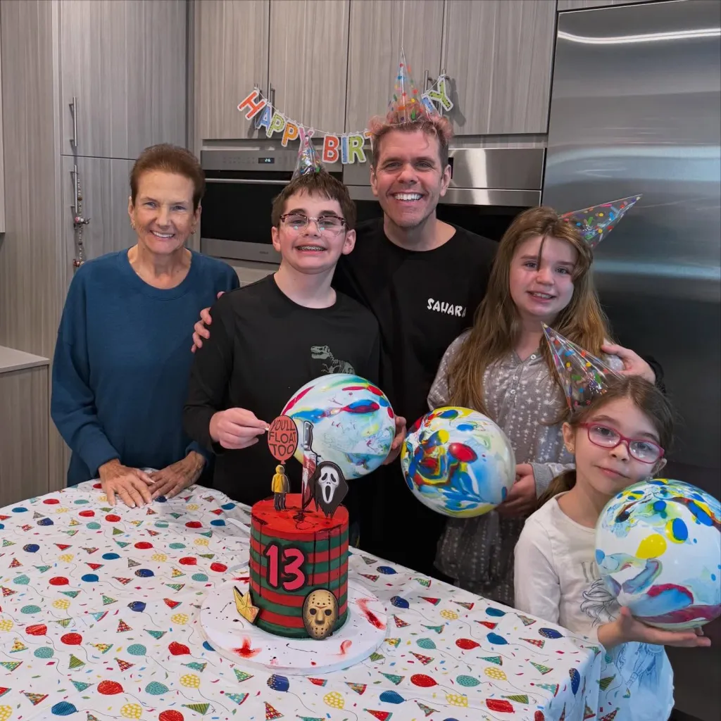 Perez Hilton with his mom and kids celebrating a birthday with a horror-themed cake.