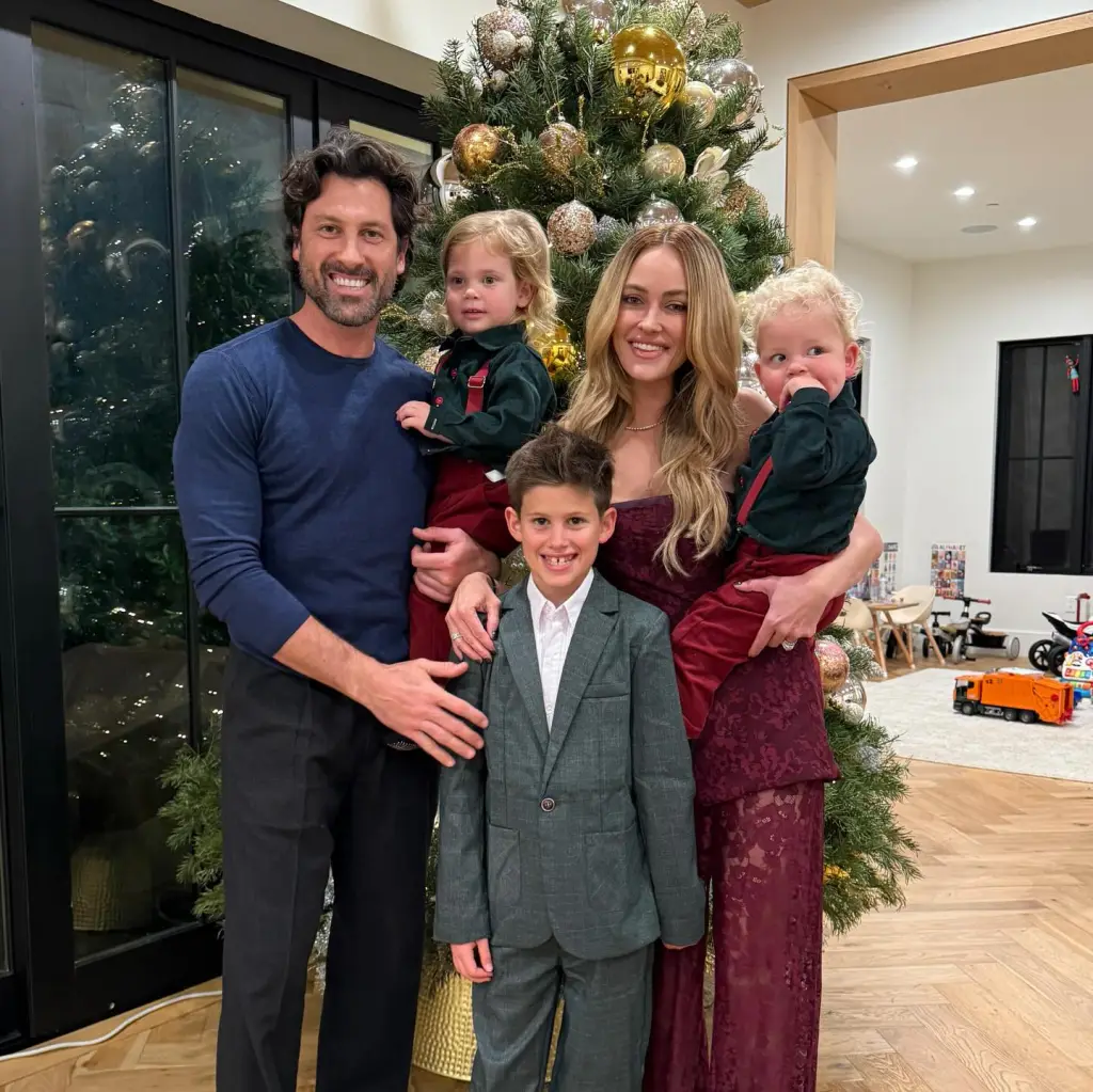 Peta Murgatroyd, Maksim Chmerkovskiy, and their three sons pose in front of a Christmas tree.