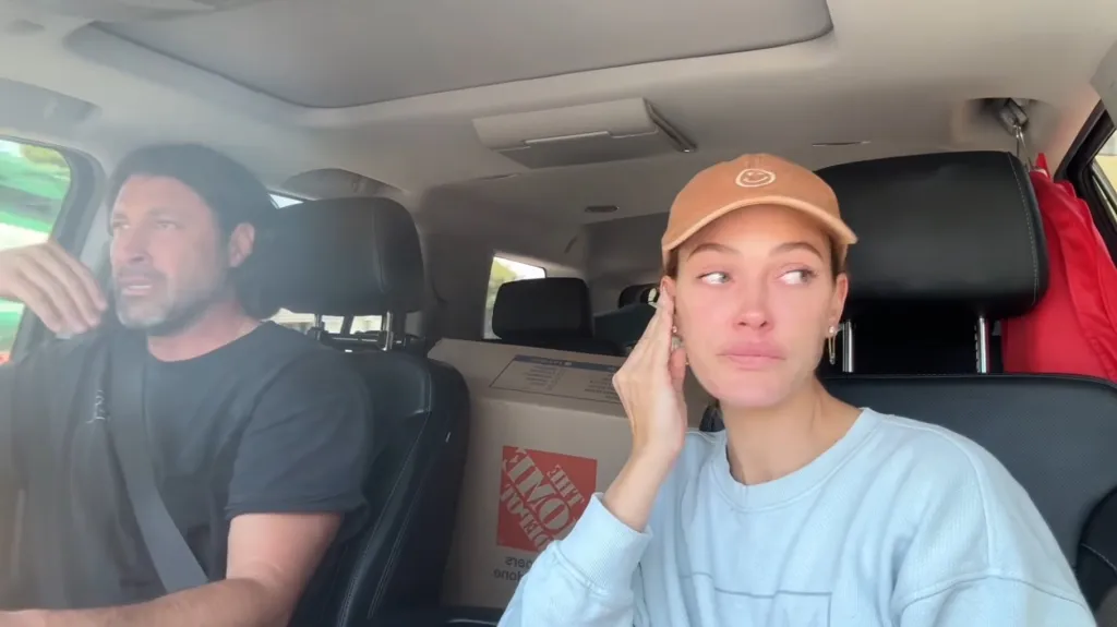 Peta Murgatroyd and Maksim Chmerkovskiy in a car with moving boxes in the back.