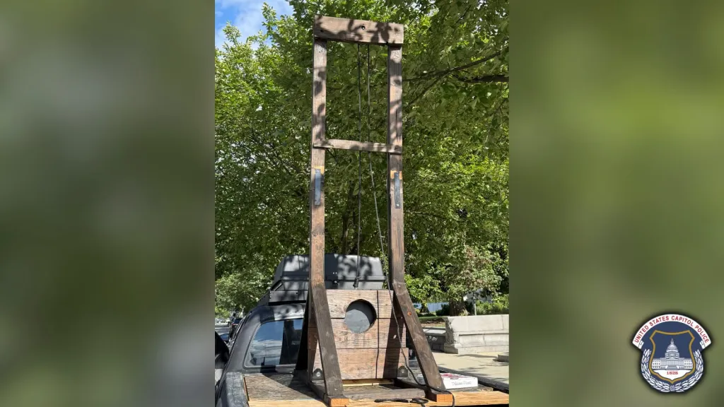 A wooden guillotine in the back of a pickup truck.