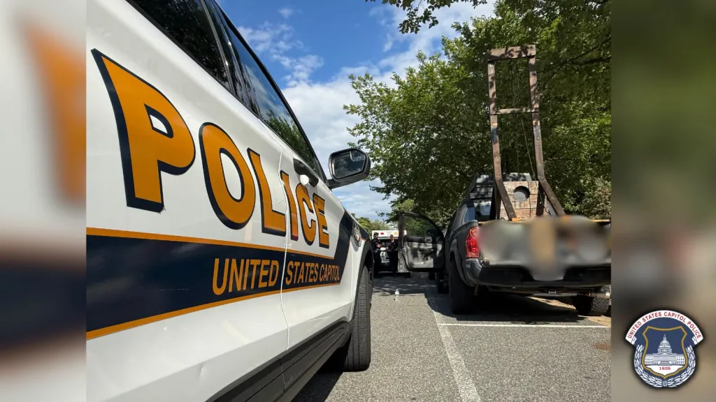 A US Capitol Police vehicle parked next to a pickup truck with a large wooden guillotine in its bed.