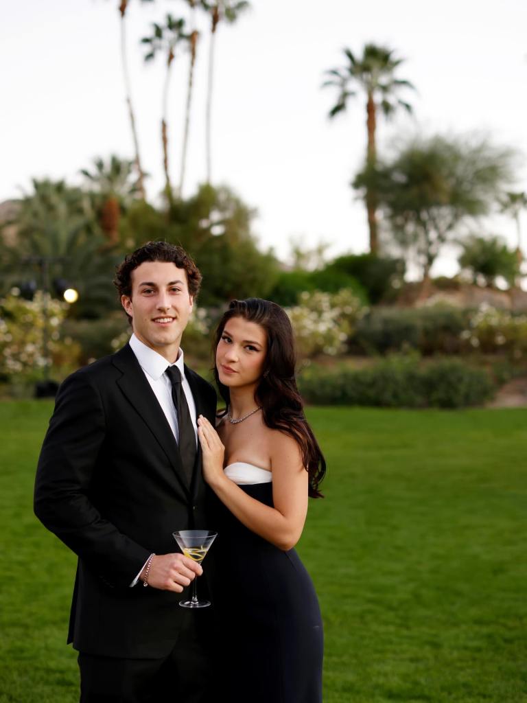 Phoebe Gates and boyfriend Chez Flynn posing outdoors, with Chez holding a martini glass.