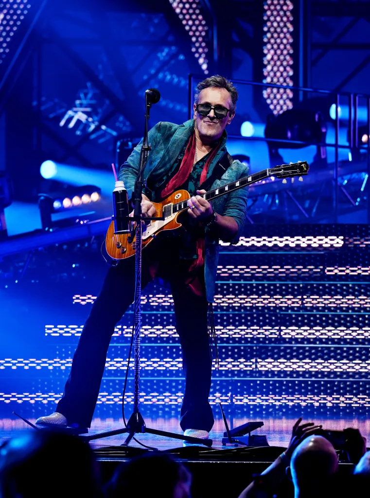 Vivian Campbell of Def Leppard performing live on stage with a guitar.