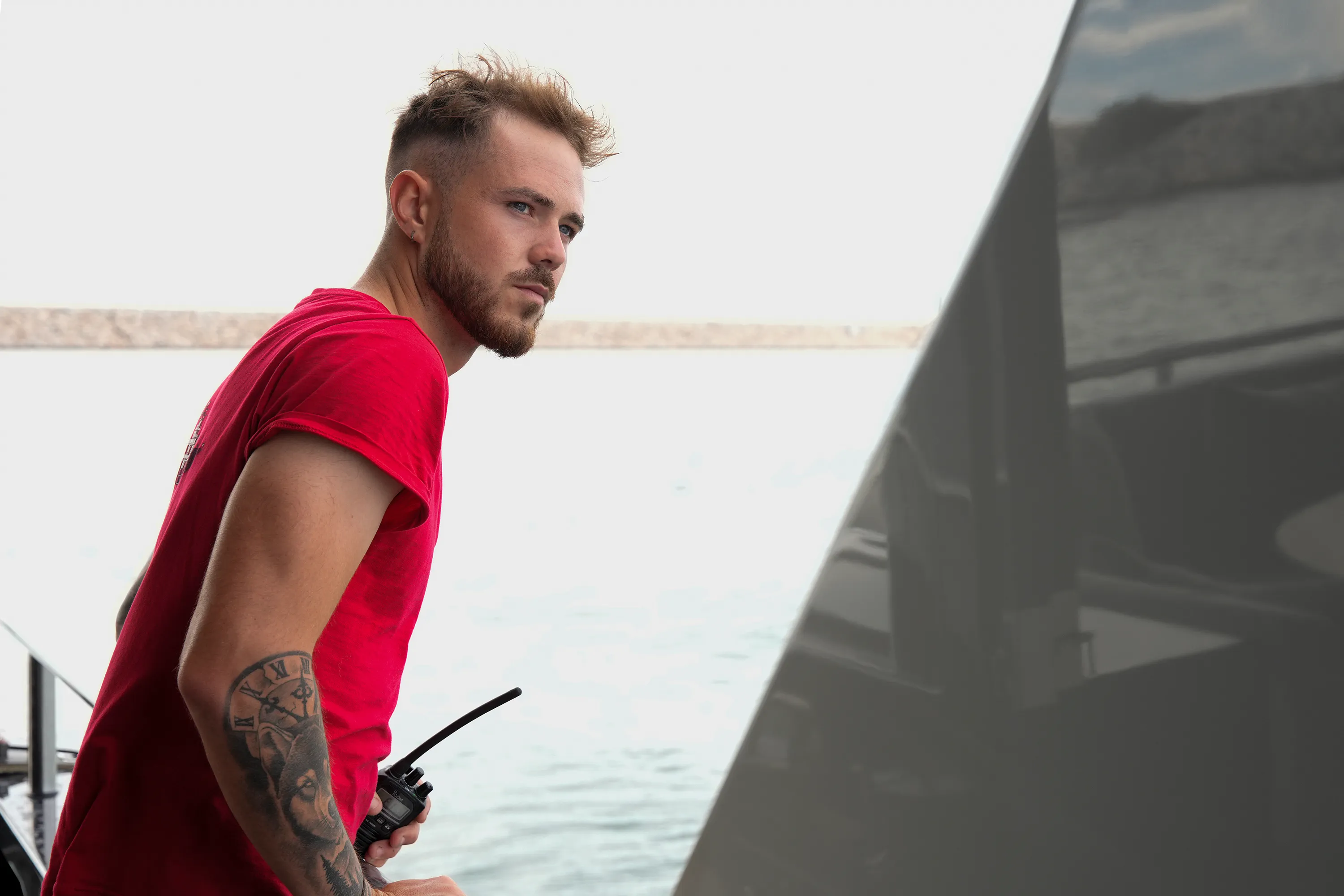 Nathan Gallagher in a red shirt holding a walkie-talkie.