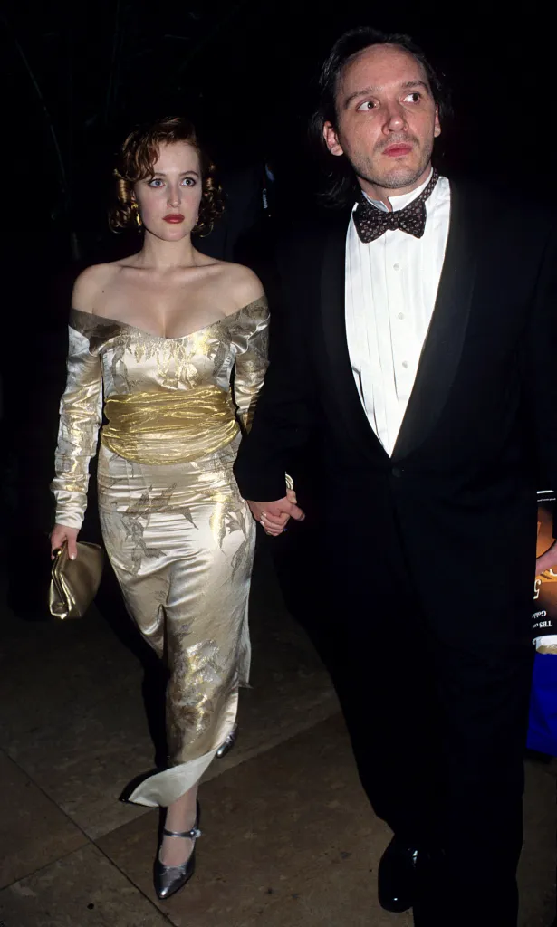 Gillian Anderson and Clyde Klotz holding hands at the 52nd Annual Golden Globe Awards.