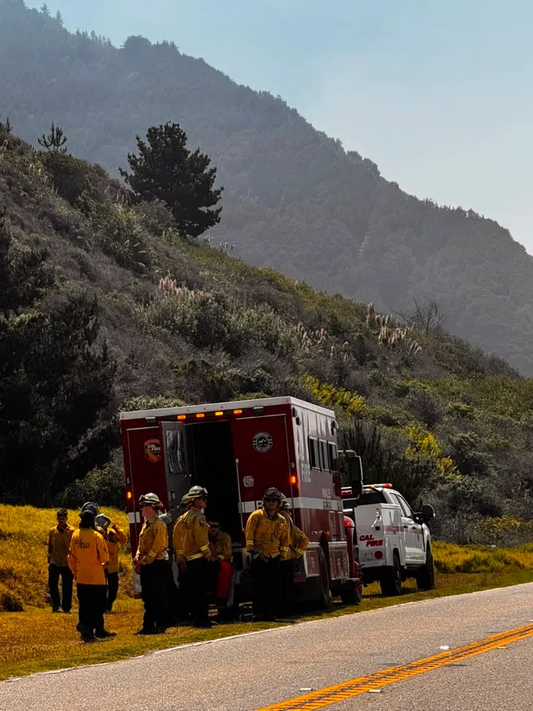 Firefighters with their vehicles by a mountain in the Plaskett area of Big Sur.