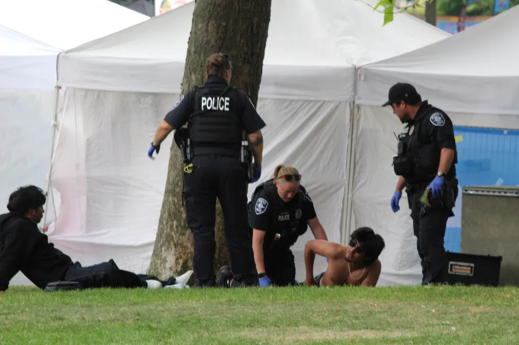 Police attend to a person after a shooting at Seattle Center during the Bite of Seattle food festival.