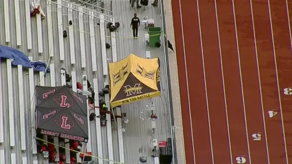Aerial view of a stadium with two tents on bleachers next to a running track, with 