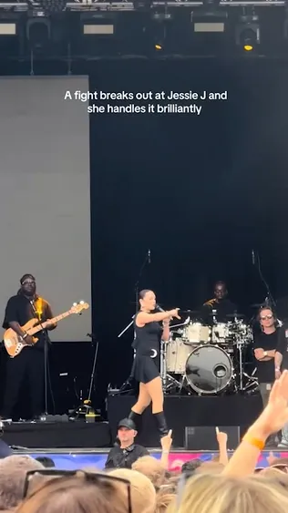 Jessie J points at a fight that broke out during her set at the Party in the Paddock festival in the UK.