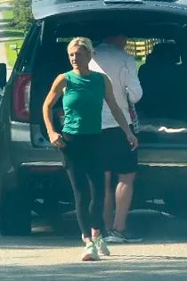 Jillian Green walking away from the back of a car, with Kroy Biermann in the background.