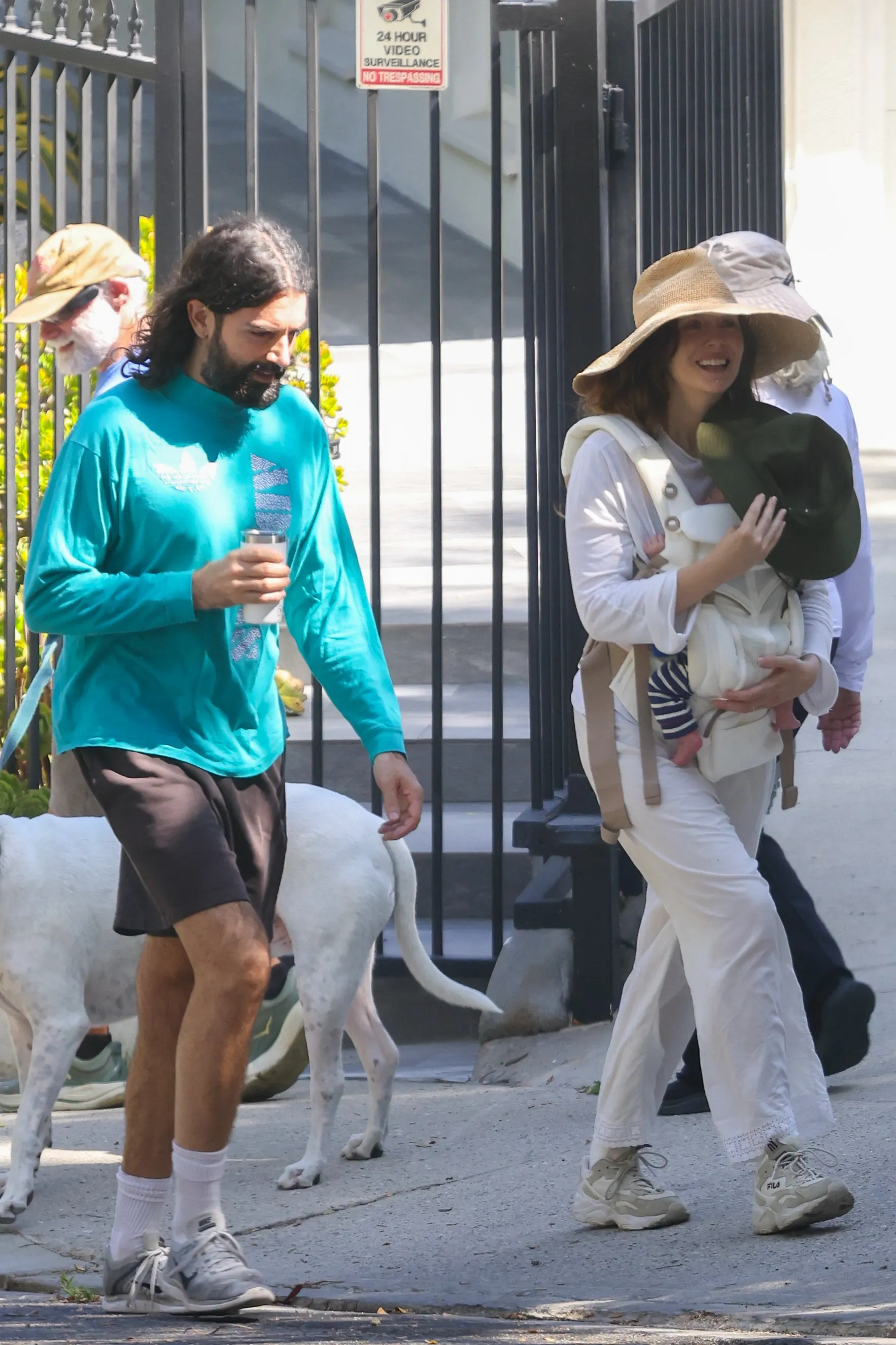 Elizabeth Olsen and Robbie Arnett walk with their newborn baby and a white dog in Los Angeles.