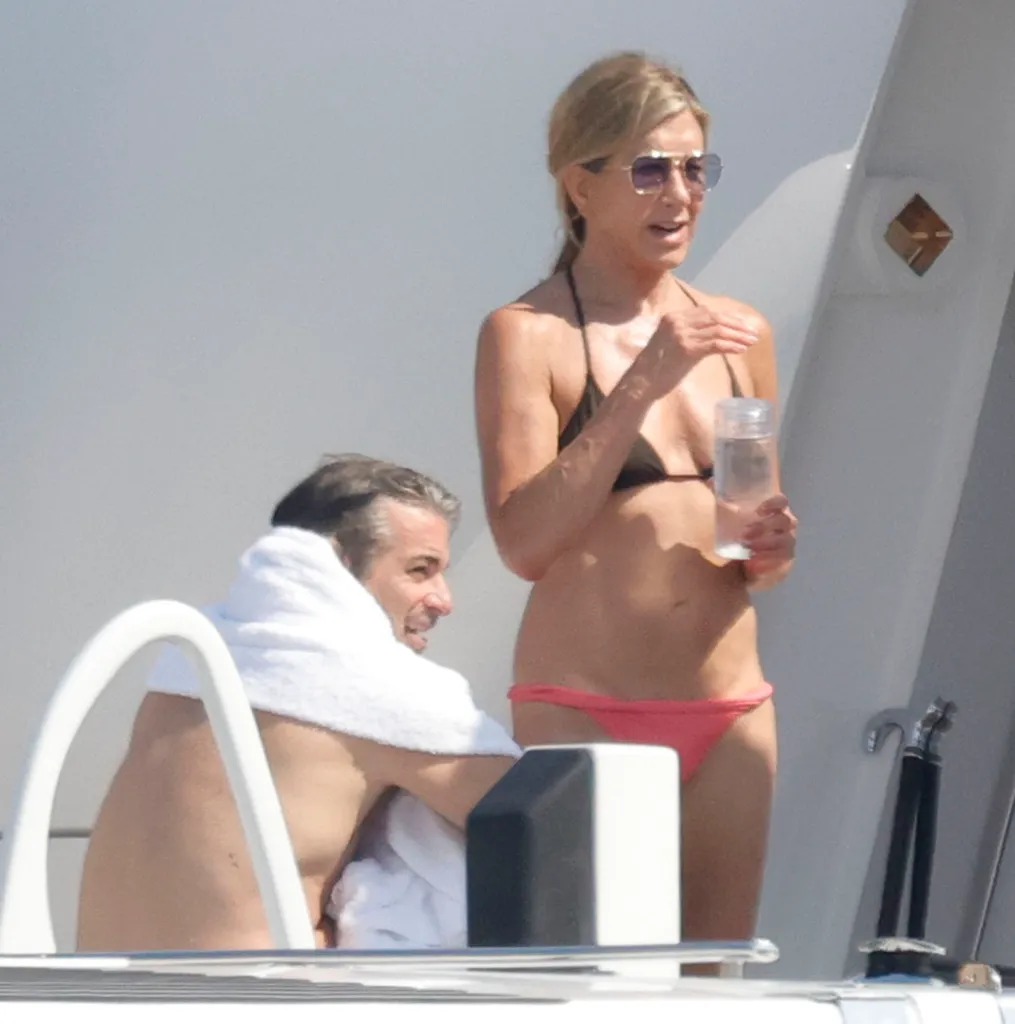 Jennifer Aniston in a bikini on a yacht with Jim Curtis.