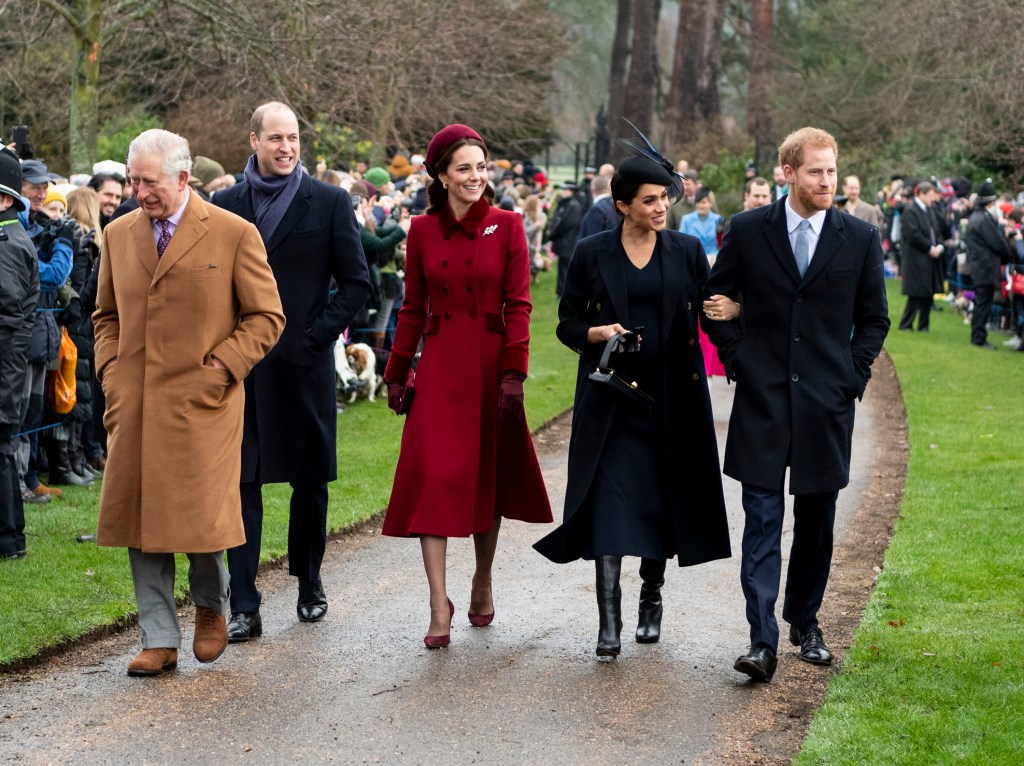 The Royal Family, including Prince Charles, Prince William, Catherine, Prince Harry, and Meghan, walking together.