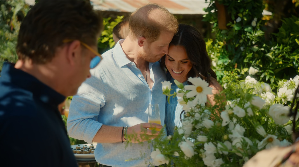 Prince Harry and Meghan Markle at an outdoor gathering.