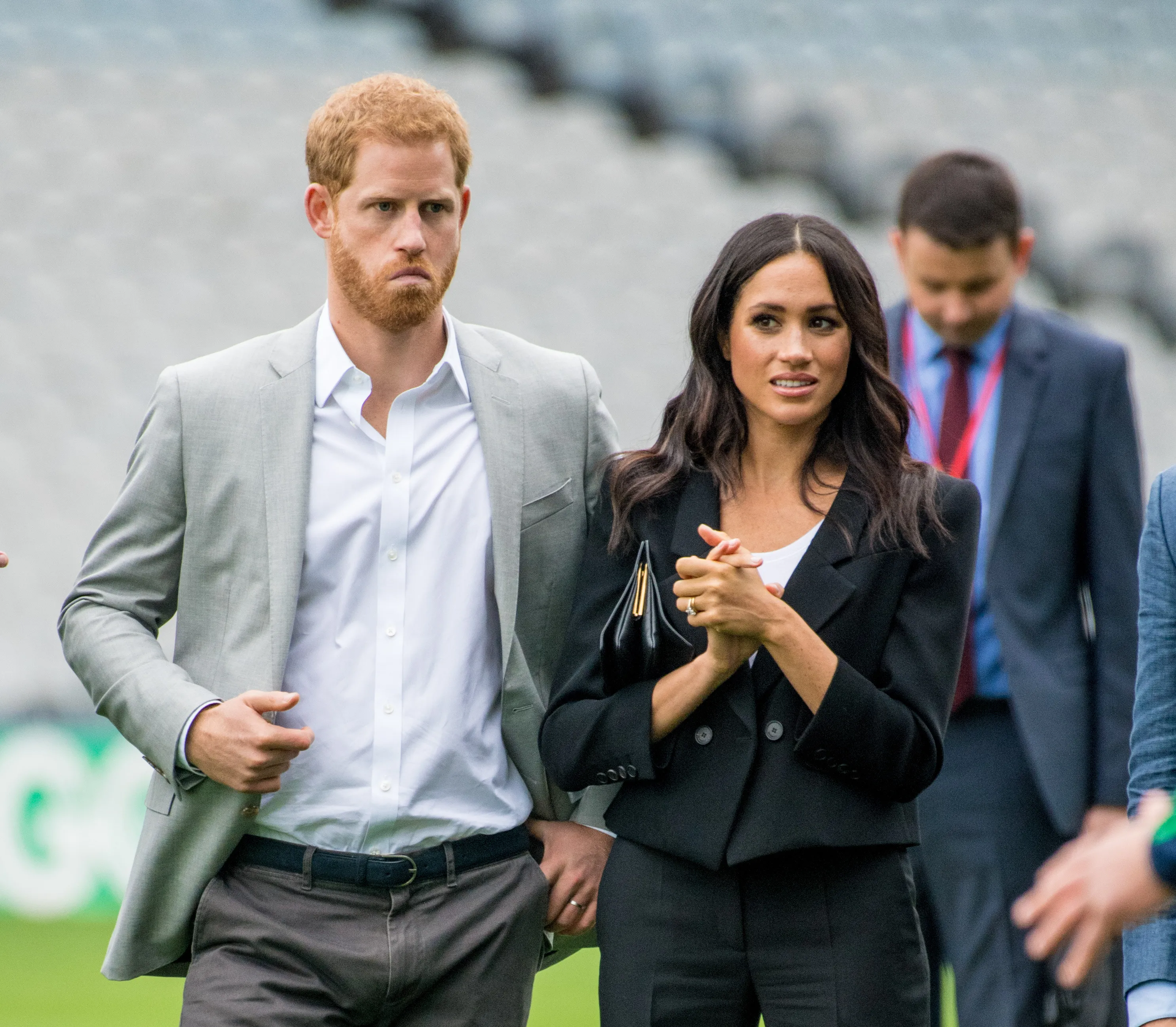 Prince Harry and Meghan Markle walking with other people.