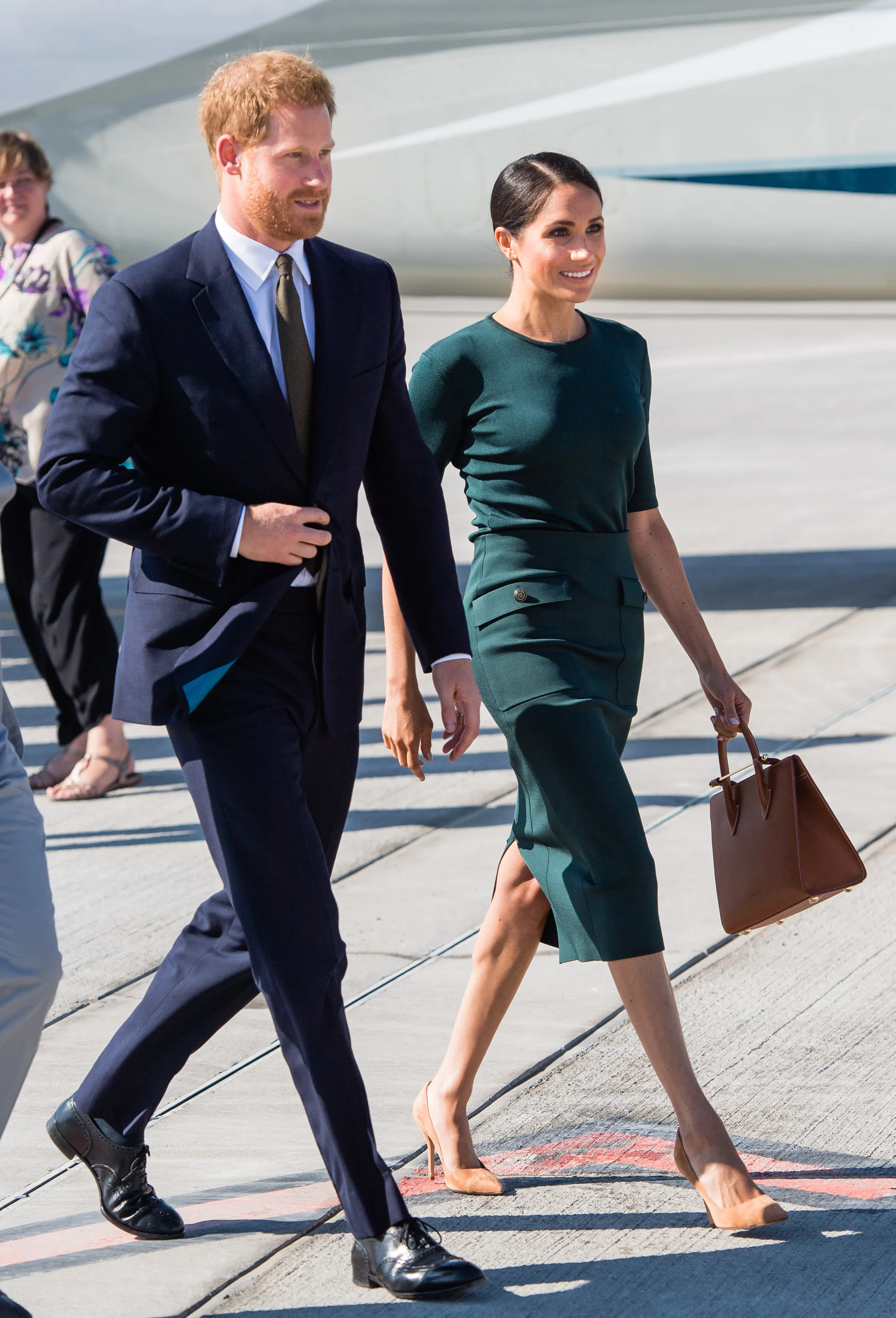 Prince Harry and Meghan Markle arrive at Dublin Airport, walking across the tarmac.
