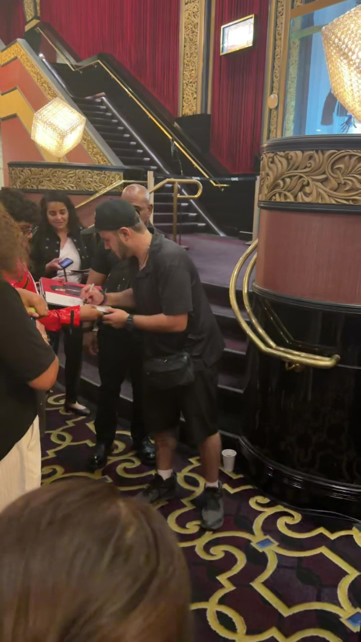 Prince Jackson signing autographs for fans at an event.