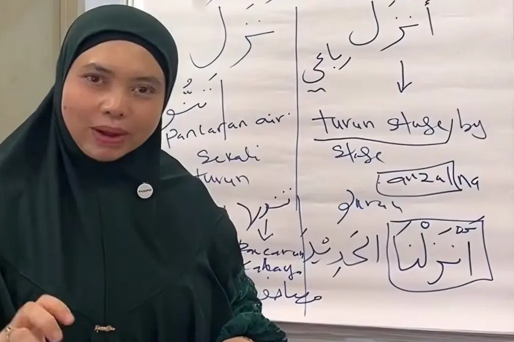Professor Solehah Yaacob speaks in front of a whiteboard filled with Arabic words and notes.