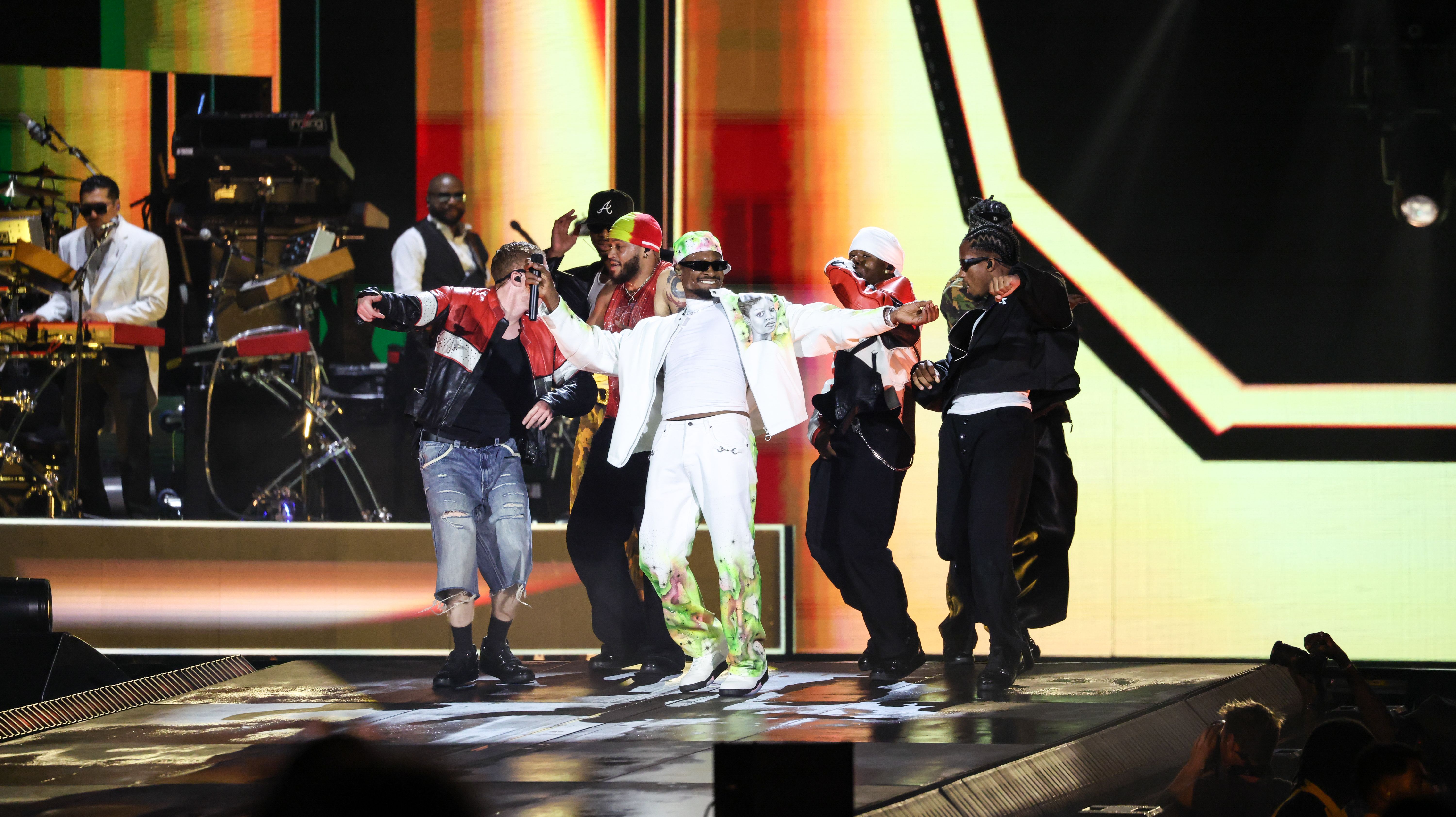Chris Brown performing on stage with dancers and musicians at MetLife Stadium.