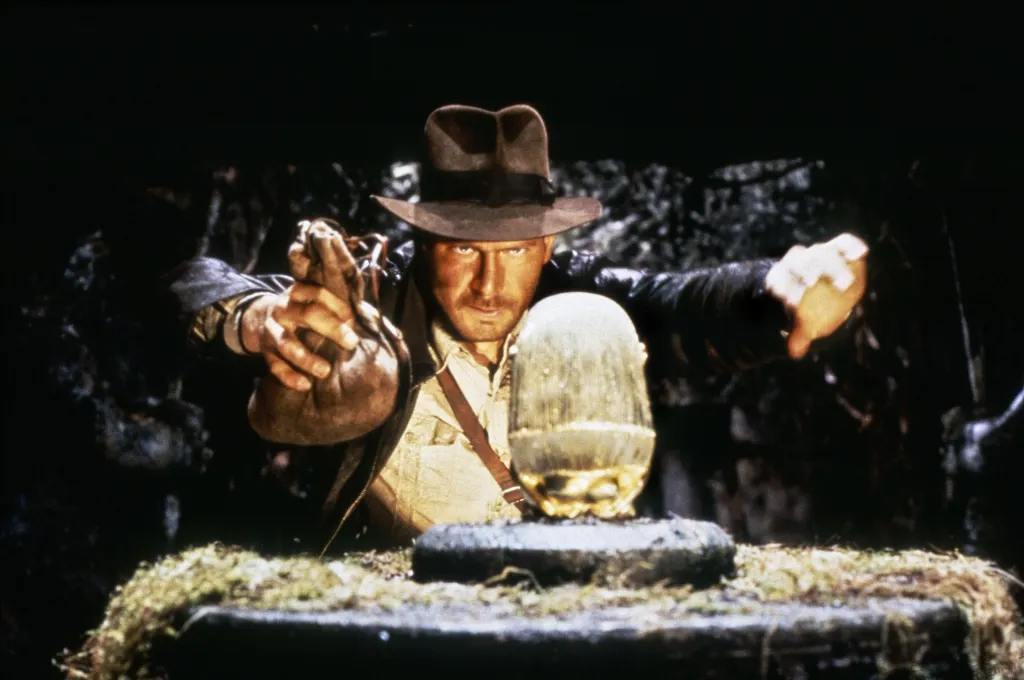 Harrison Ford as Indiana Jones, poised to replace an idol with a bag of sand.