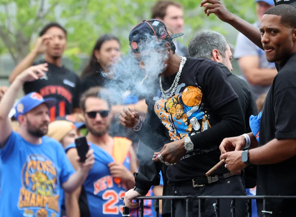 Rapper A Boogie Wit da Hoodie exhales smoke from a cigar during the 2026 NBA Champion New York Knicks ticker-tape parade.