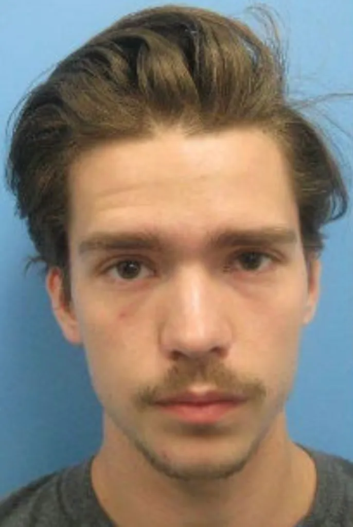 Mugshot of Tyler Boebert, a young man with brown hair and a mustache, looking directly at the camera.