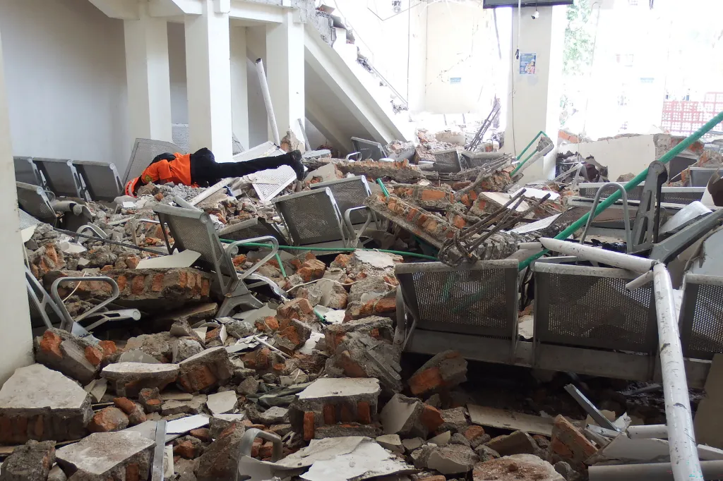 A rescue team looks for people underneath a pile of rubble inside the ruins of the Laurensius Say Port on Aug. 15, 2026.