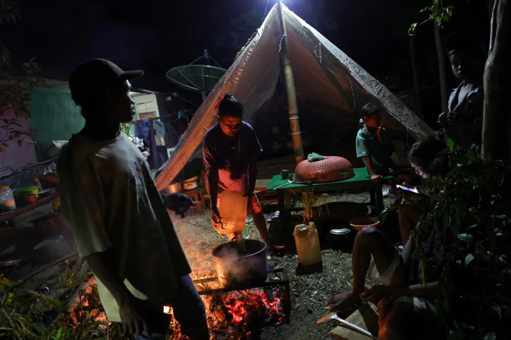 Residents cooking outdoors after an earthquake in Poco village, Indonesia.