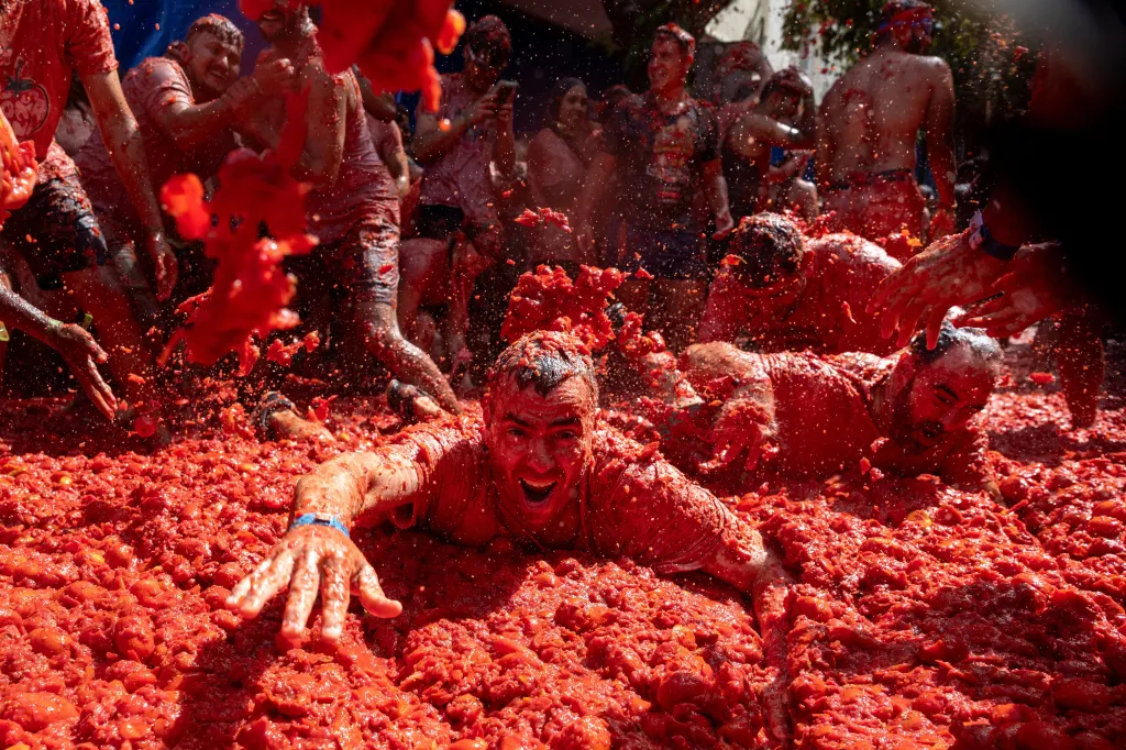 Revelers immersed in smashed tomatoes during the La Tomatina food fight festival in Buñol, Spain.