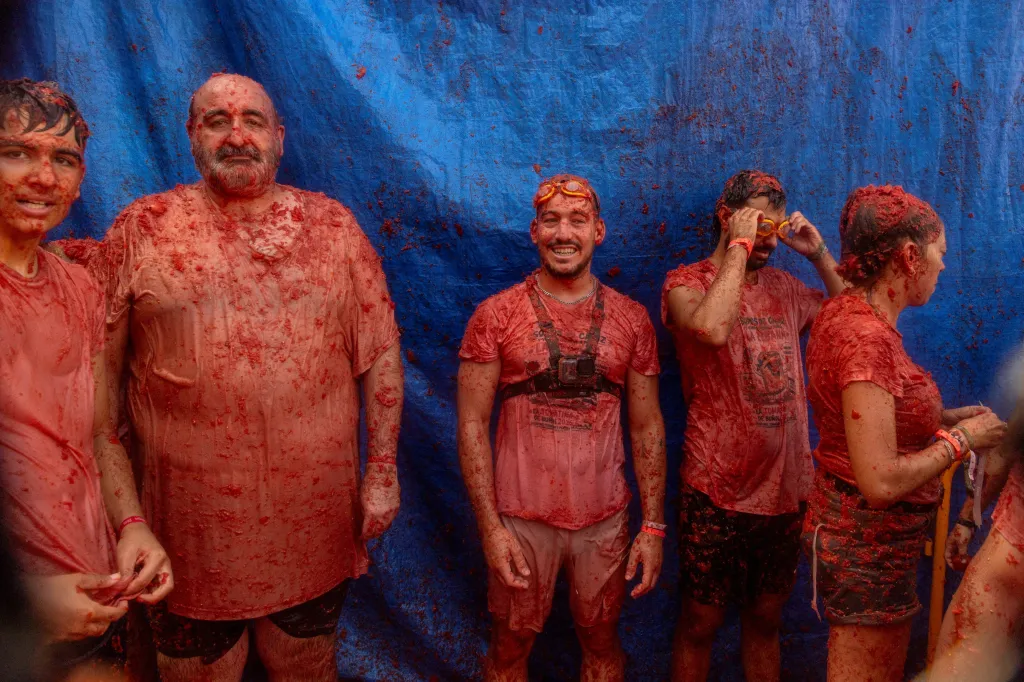 Five revelers covered in tomato pulp after the La Tomatina food fight festival.