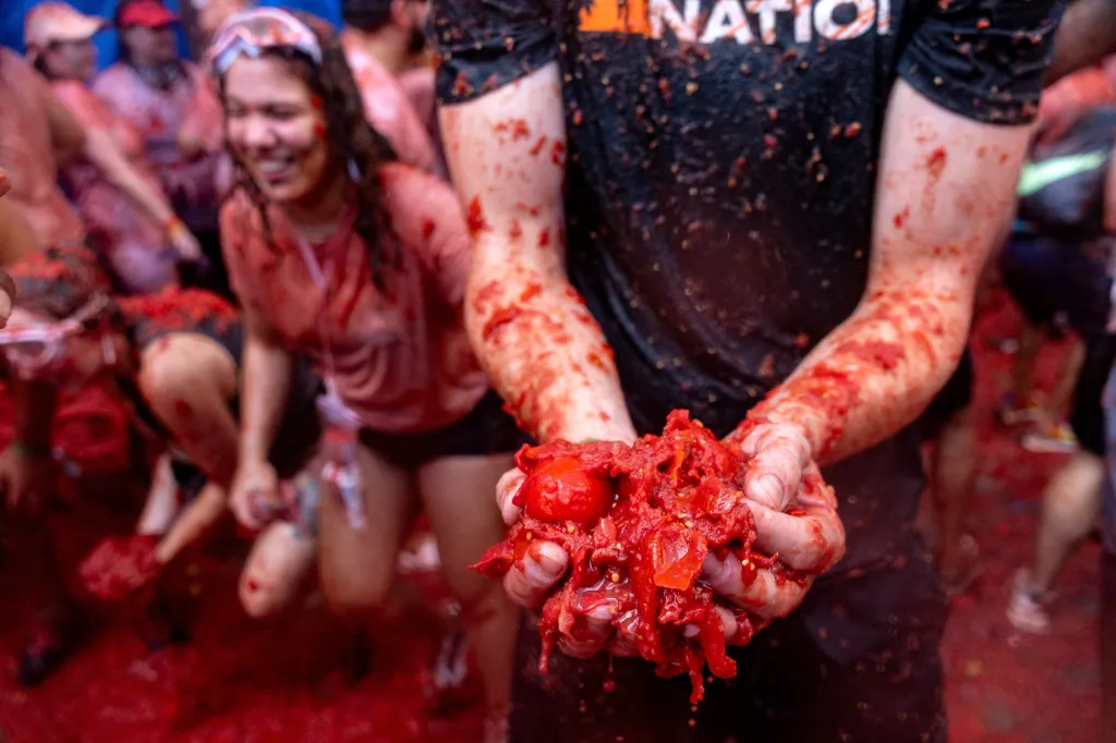 A man with hands full of squashed tomatoes at the La Tomatina festival.