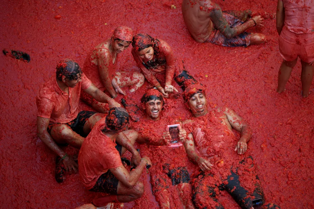 Revelers lie in tomato pulp during the La Tomatina food fight festival in Bunol, Spain.