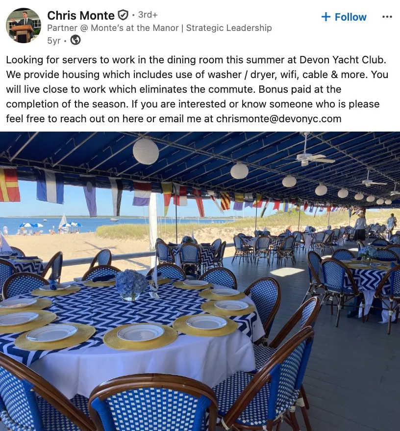 An outdoor dining area at Devon Yacht Club with blue and white decor, overlooking a beach.