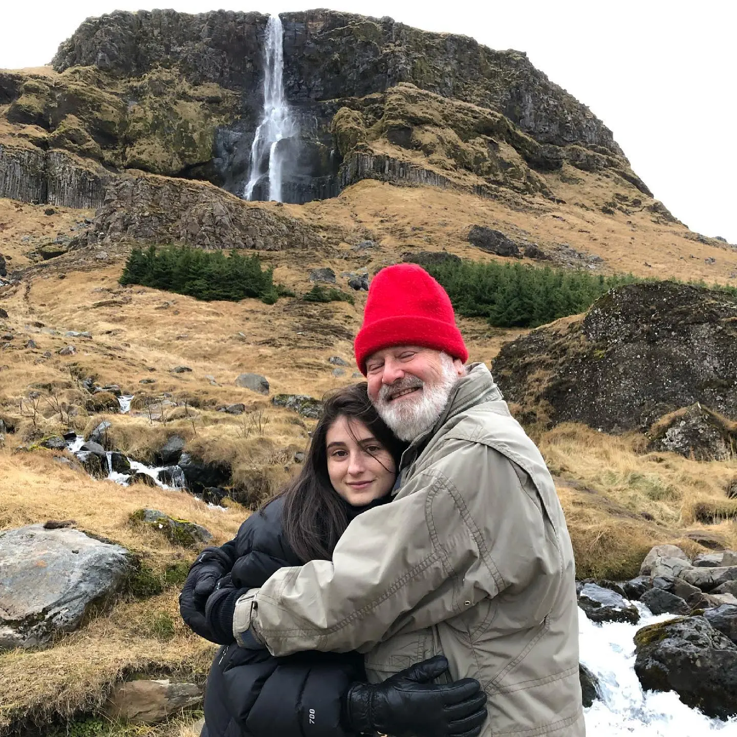 Rob and Romy Reiner embracing in front of a waterfall.