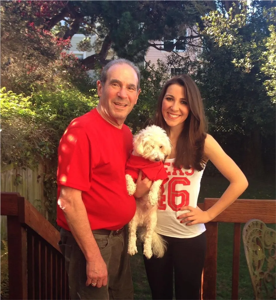 Ronn Owens and daughter Laura Owens with a small white dog.
