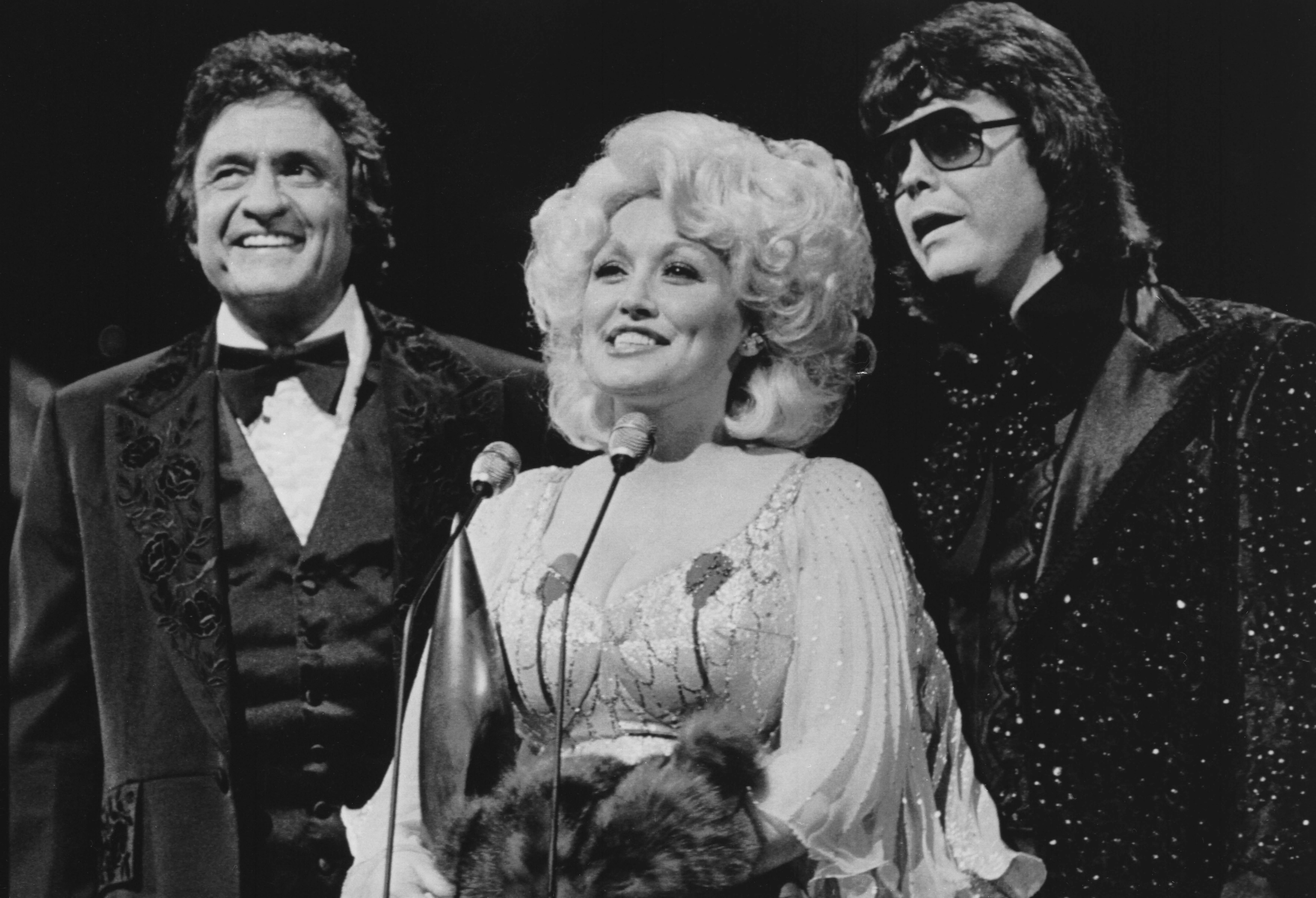 Dolly Parton accepts the Entertainer of the Year award, flanked by Johnny Cash and Ronnie Milsap.