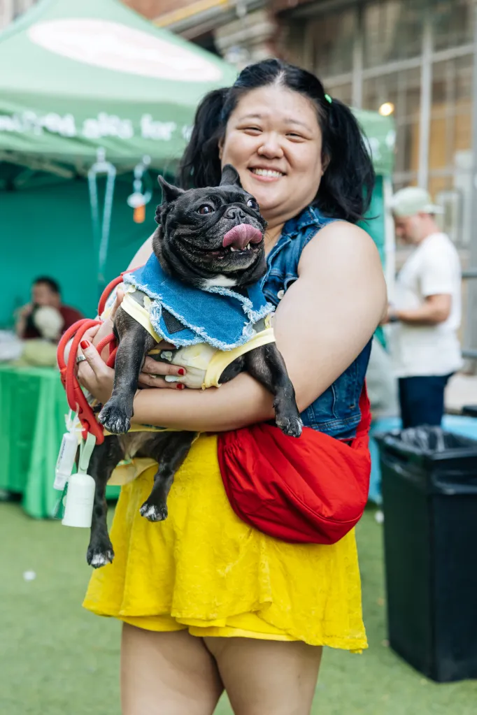 Rosa McGee holding Lisa, a black French bulldog, both smiling at the Dogfish Head Look-a-Like contest.