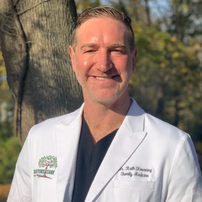 Dr. Keith Hoerning, a family physician, smiles while wearing a white lab coat.