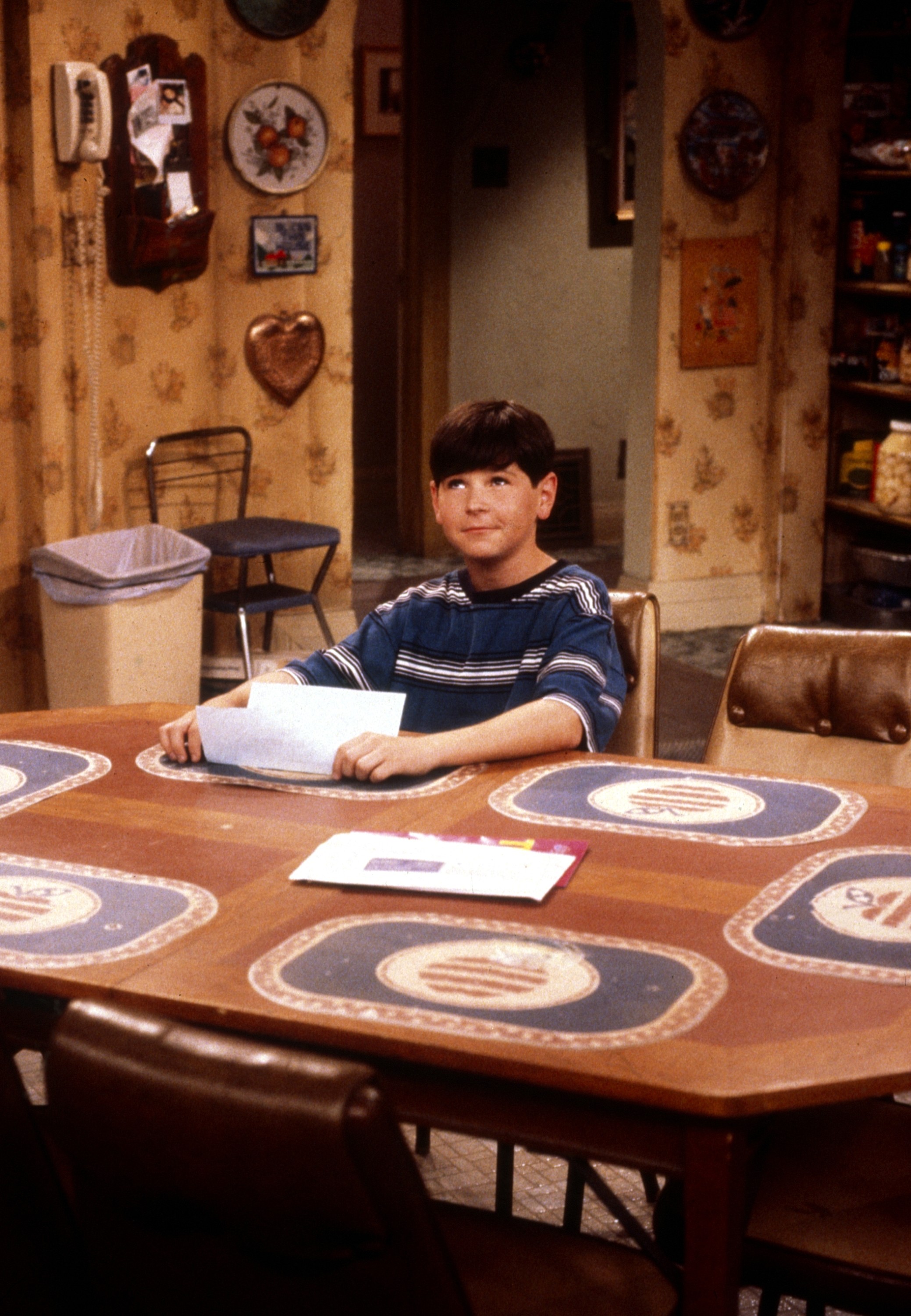 Michael Fishman as D.J. Conner at the kitchen table.