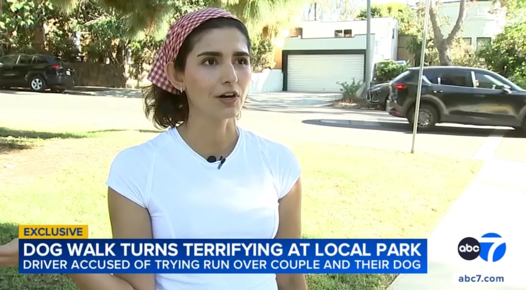 A woman in a white shirt and red and white checkered bandana being interviewed about a terrifying dog walk.