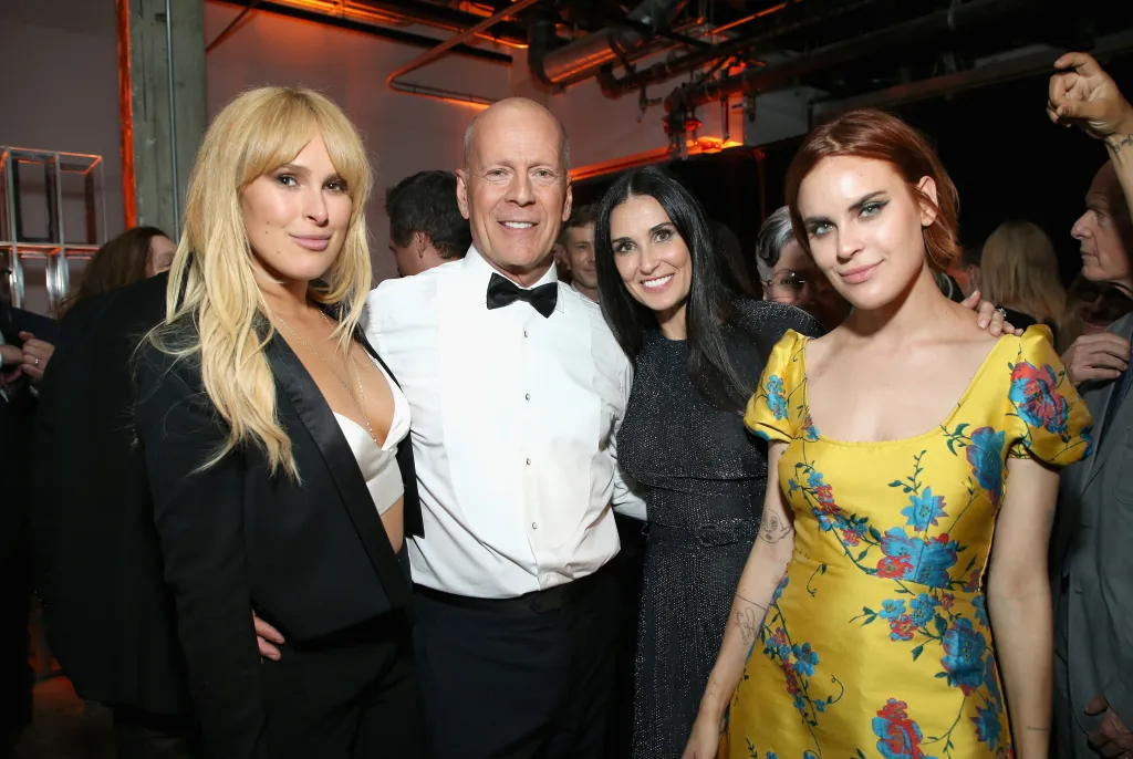 Rumer Willis, Bruce Willis, Demi Moore and Tallulah Belle Willis smiling for a photo.