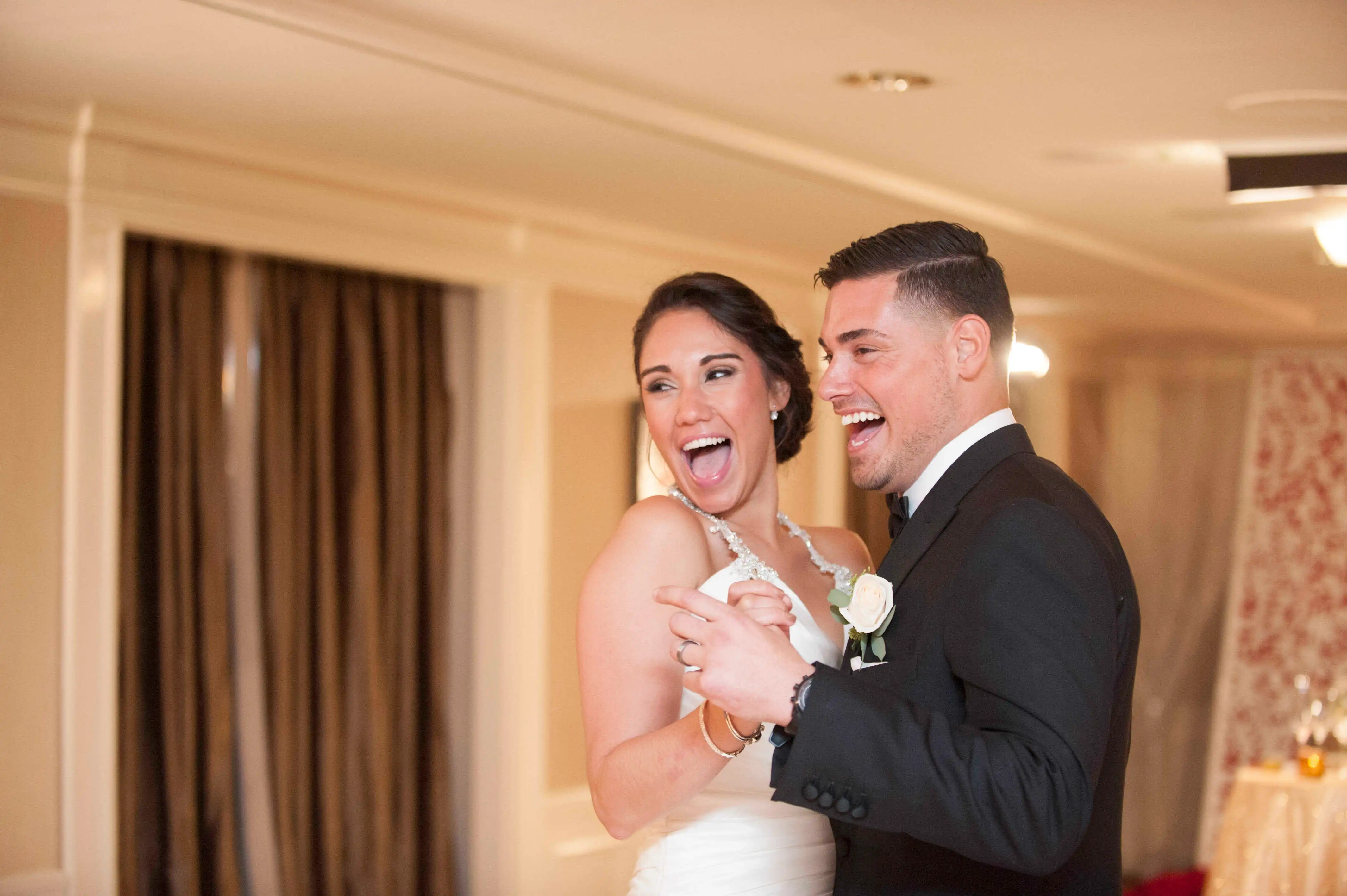 Jessica and Ryan de Nino laughing at their wedding.