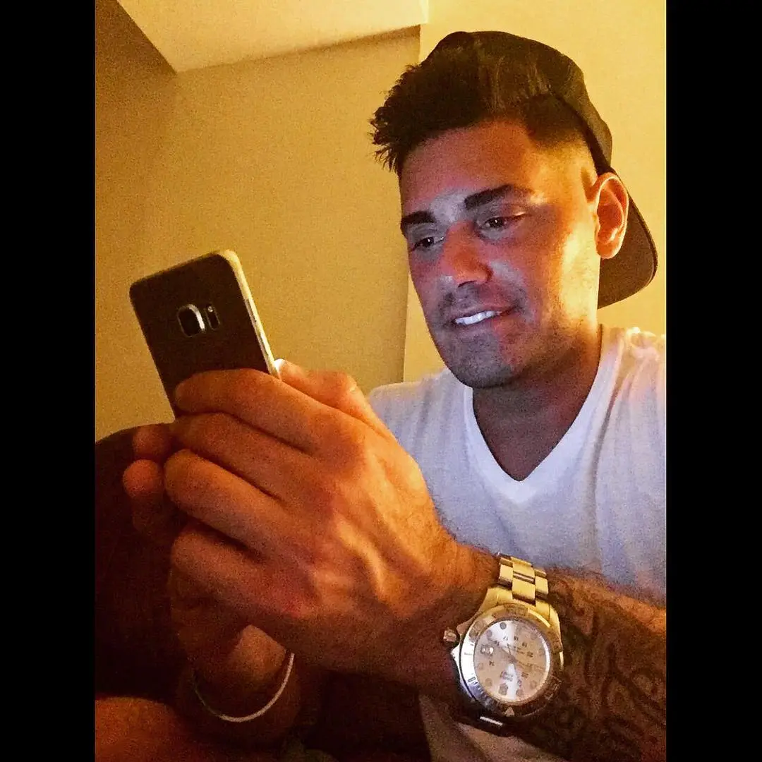 Reality TV star Ryan De Nino looking at his phone.