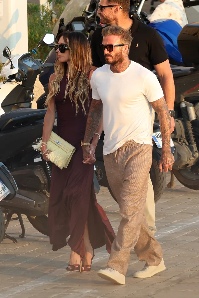 David and Victoria Beckham walking and holding hands.