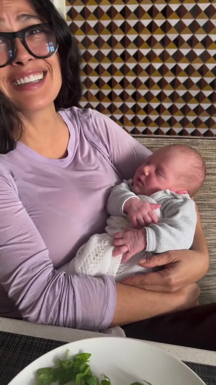Salma Hayek holding her newborn grandson.