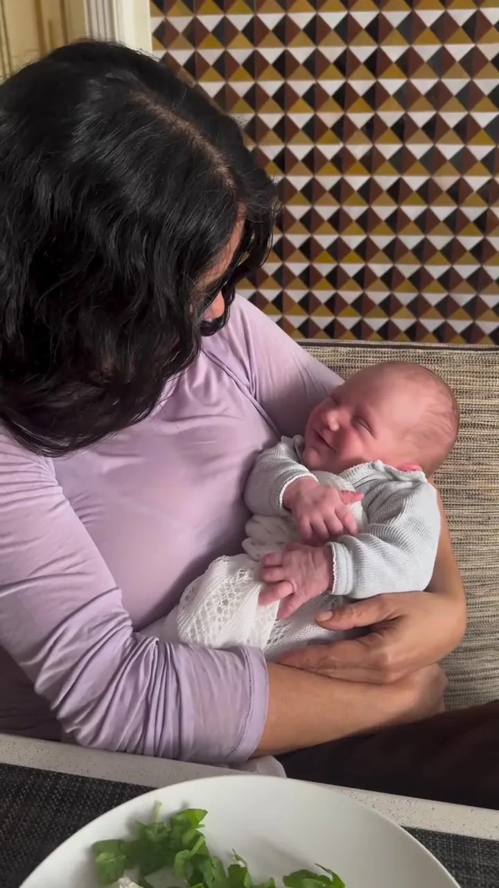 Salma Hayek holding her newborn grandson.